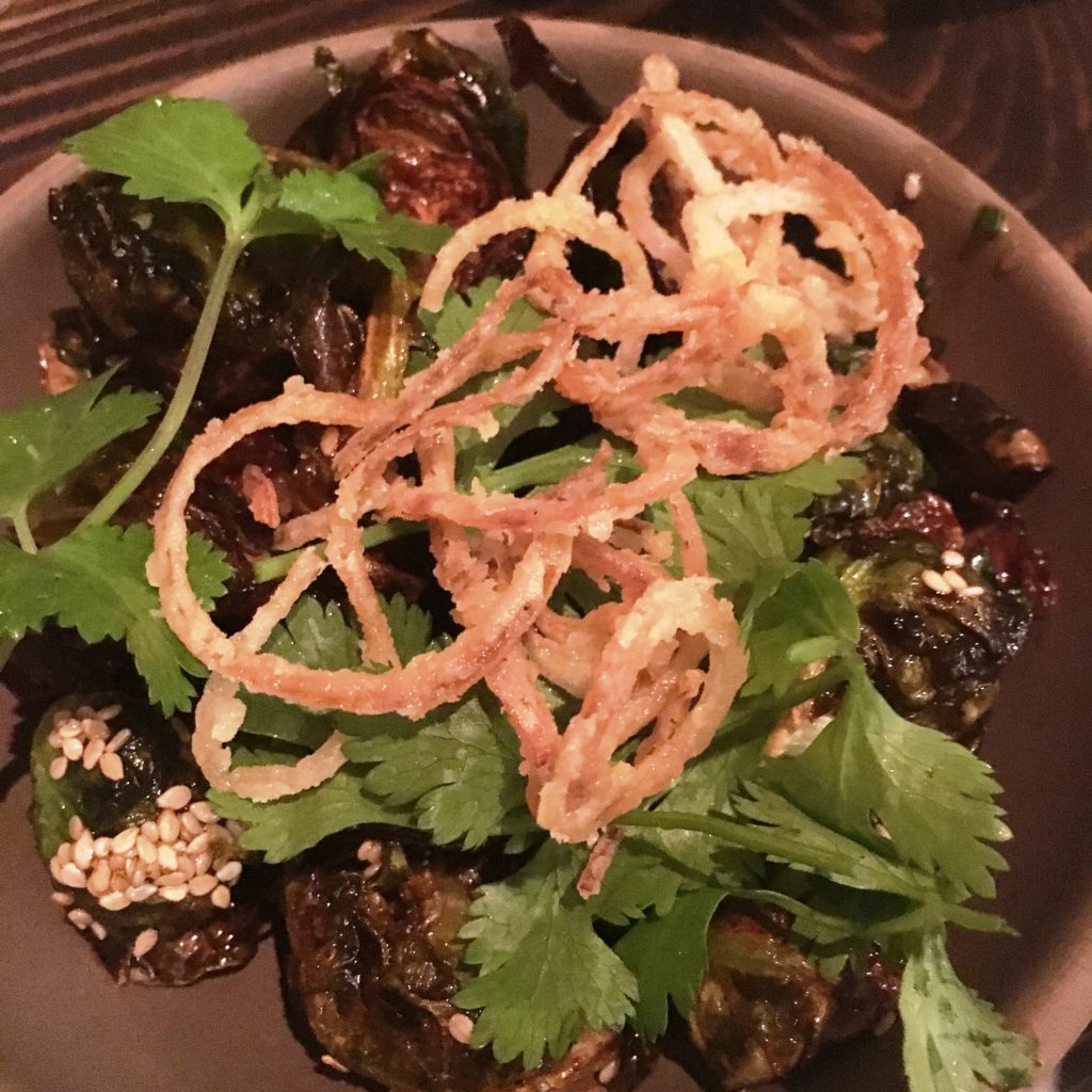 BRUSSELS SPROUTS charred on the fire with sesame seeds, parsley, and crispy onions