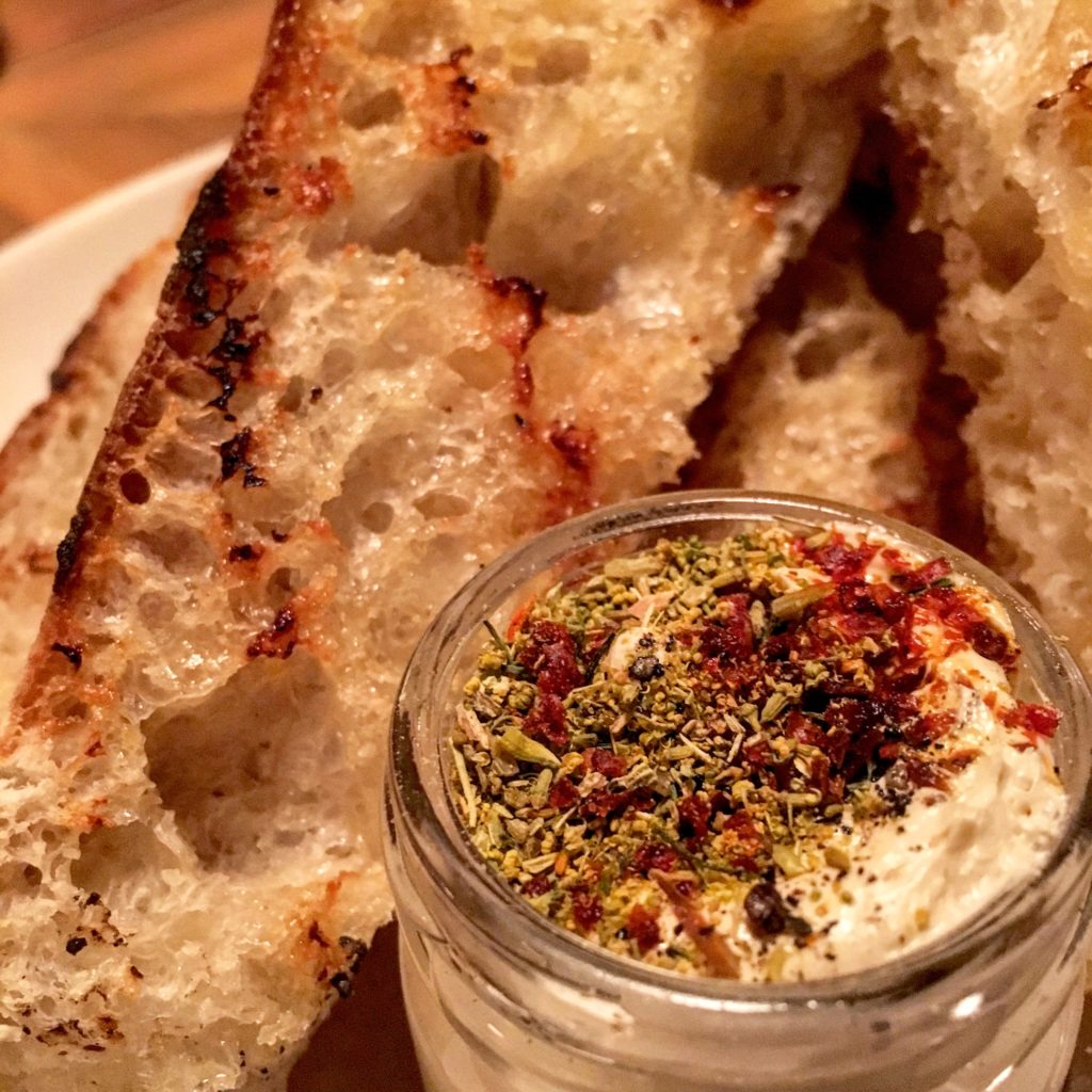 Housemade bread, toasted on the fire, with a sweet and salty herbed butter 