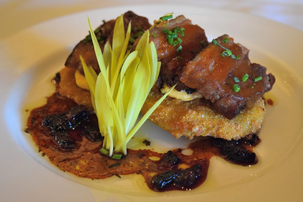 Crispy Berkshire pork belly served atop fried green tomatoes, pimento cheese and bacon gastrique.