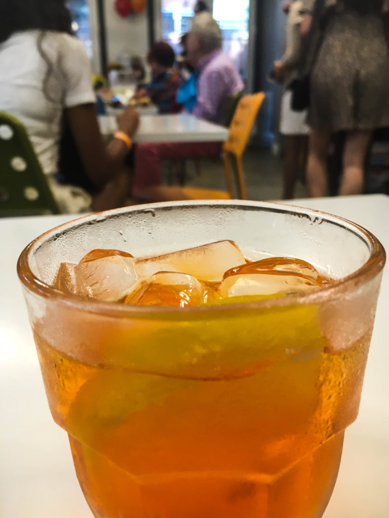 The Aperol Spritz - aperol, prosecco, and soda water garnished with an orange wedge. 