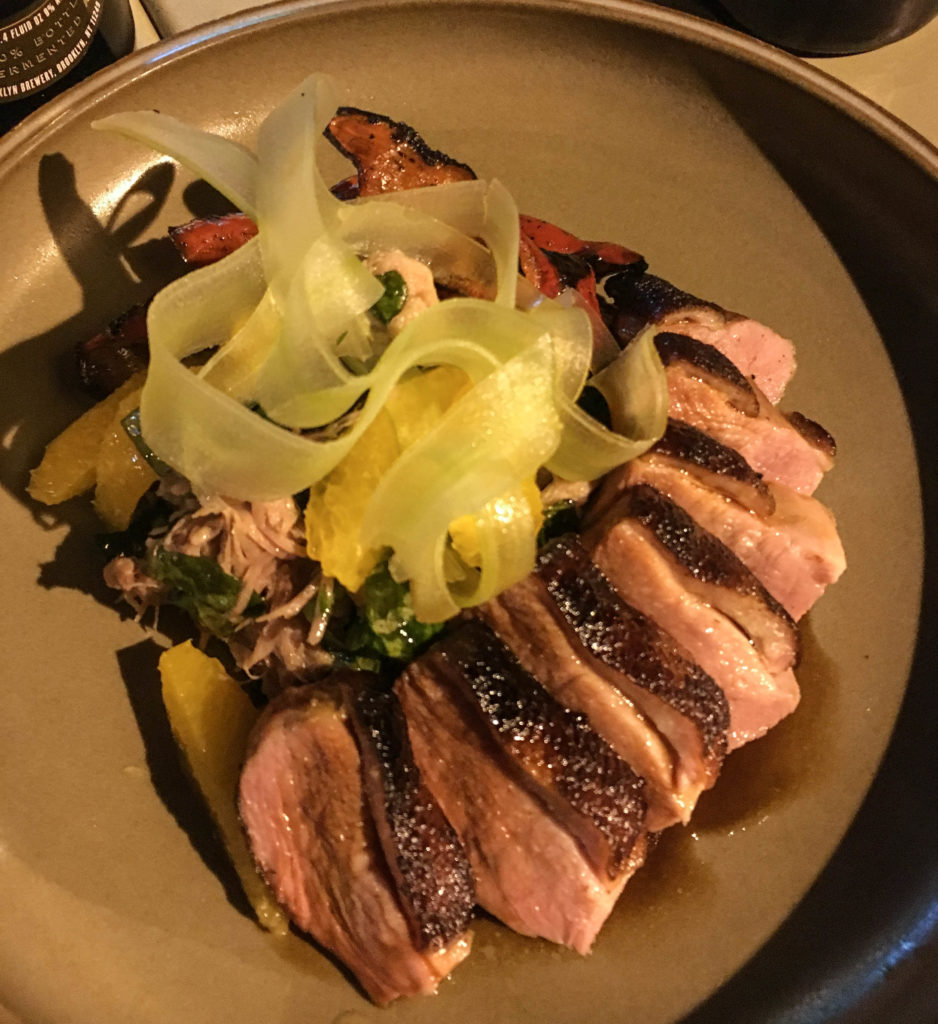  Seared duck breast, confit leg, celery, orange, grilled shishito peppers, and duck demi glace